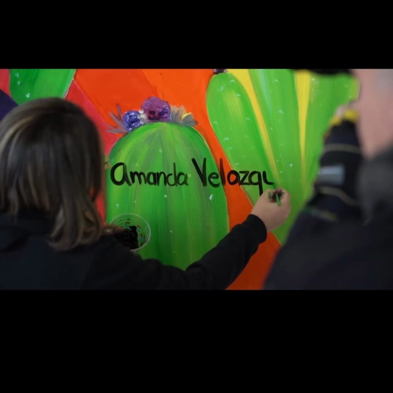 Amanda firmando su mural